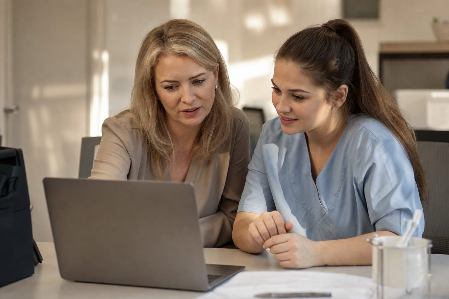 Zwei Personen im Büro besprechen am Laptop die offene Stelle